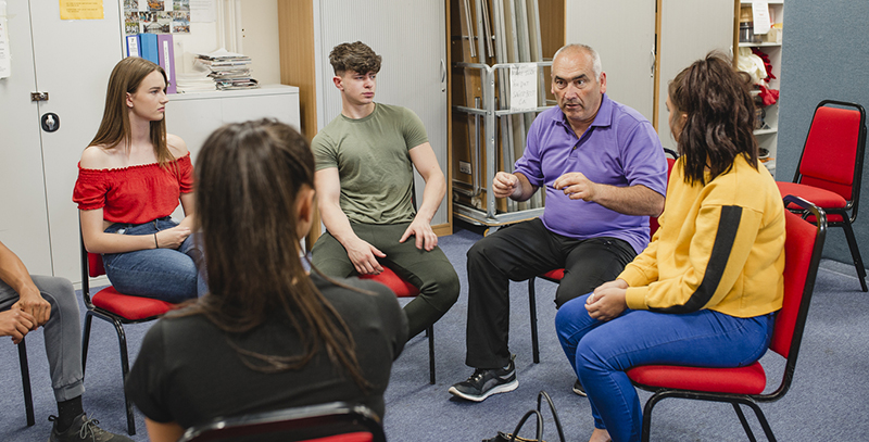 Four people in discussion sat on chairs in a circle